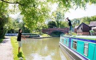 A father and son tying up their narrowboat in a guide to narrowboat mooring for beginners